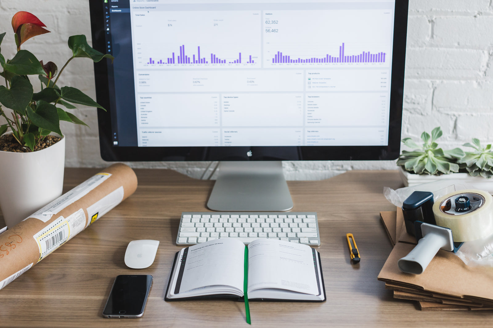 Commerce dashboard on a desk with shipping materials and an order planner