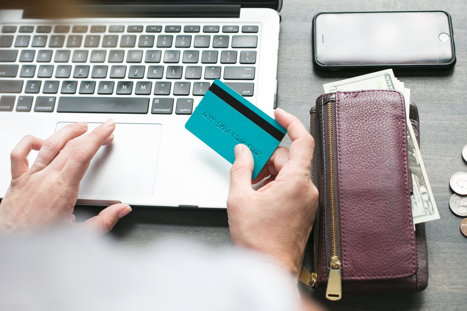 Shopper using a laptop and holding a payment card