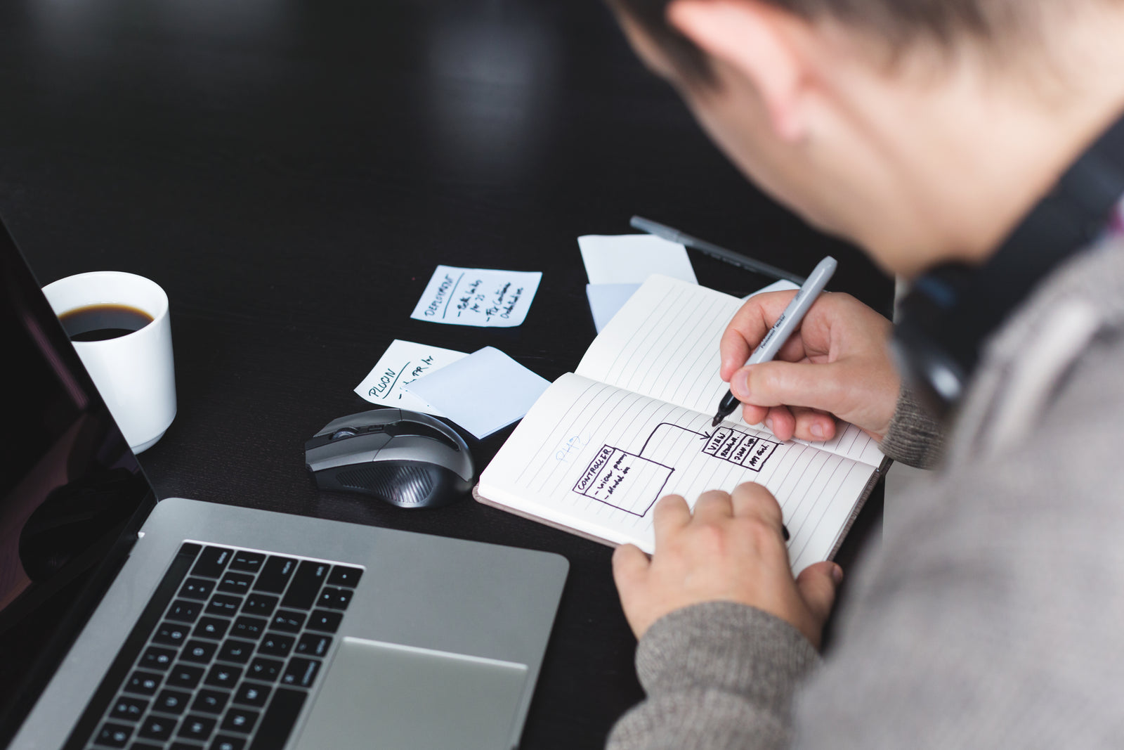 Developer drawing a software architecture plan in a notebook