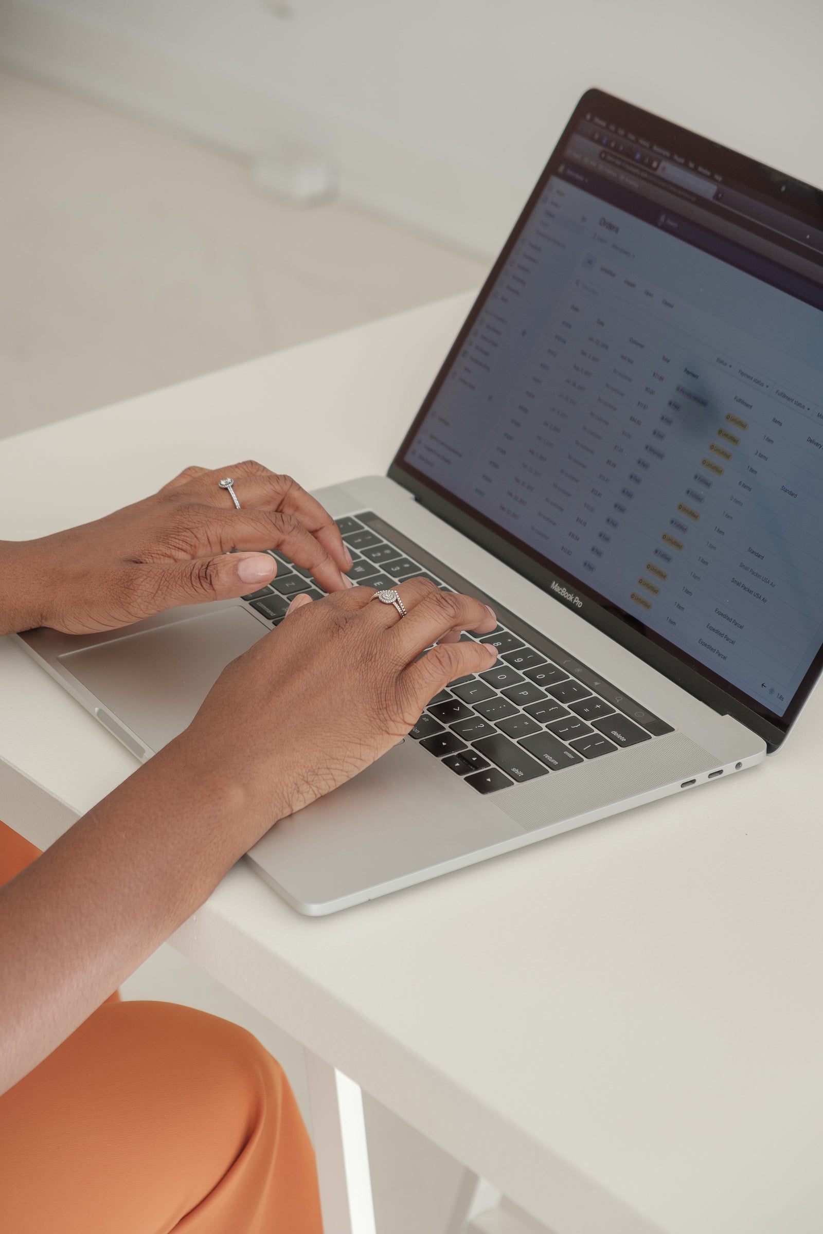Hands working in a Shopify store admin on a laptop