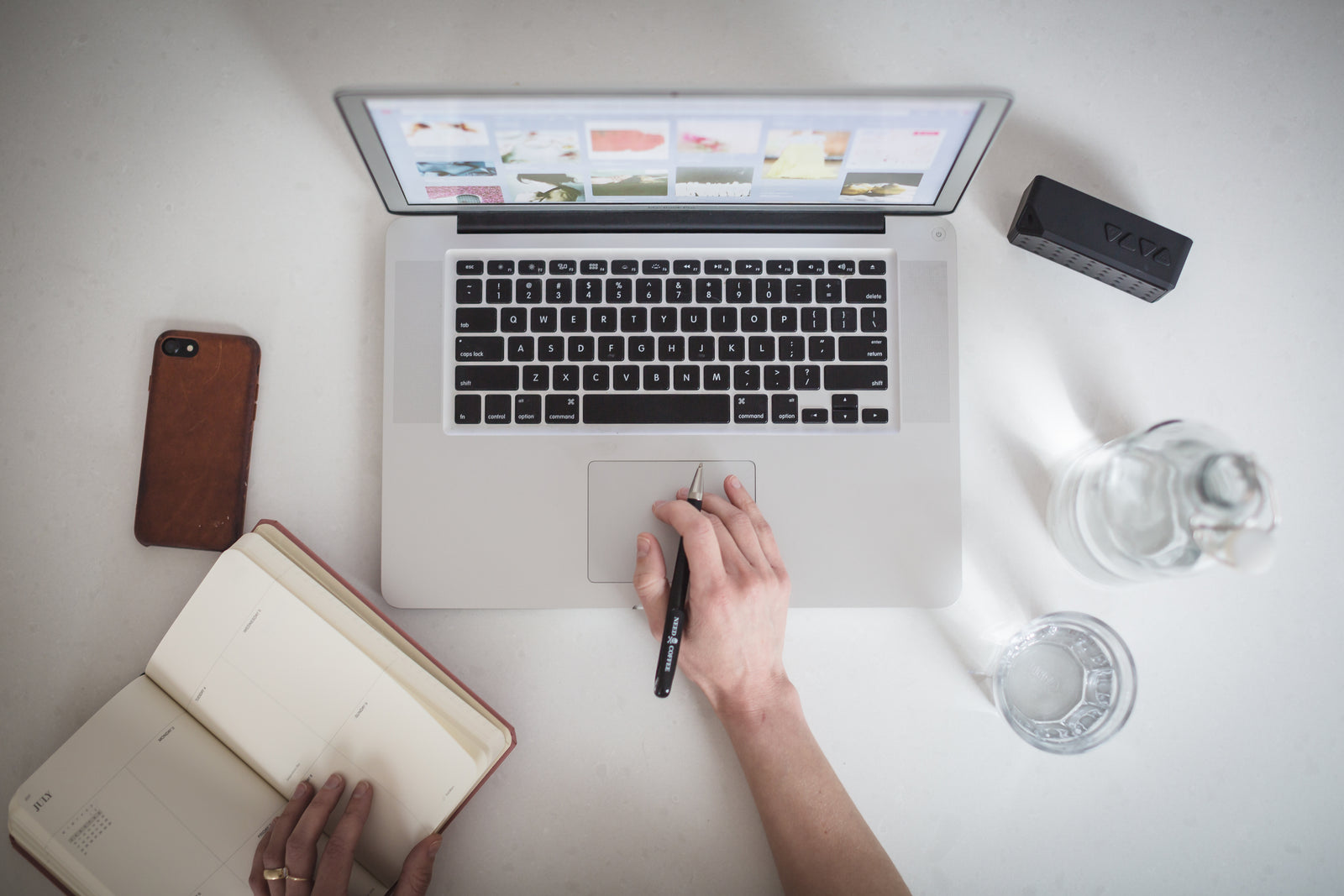 Website designer working with a laptop and planning notebook
